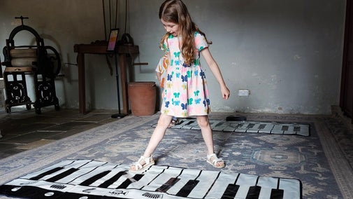 Girl playing the floor piano in the old laundry room at Ormesby Hall